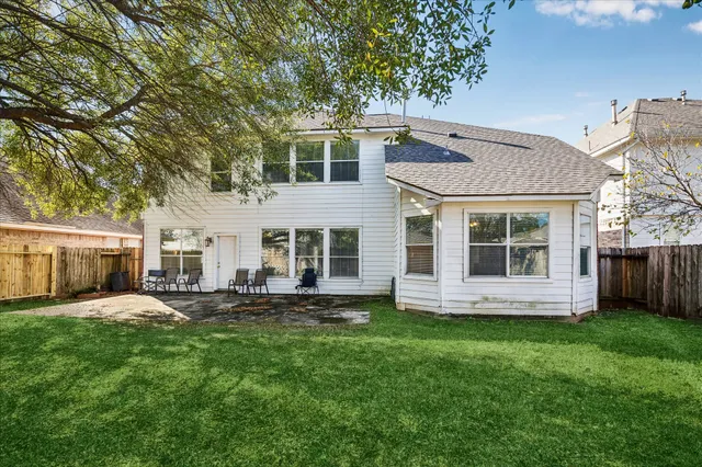 a front view of a house with a yard and trees