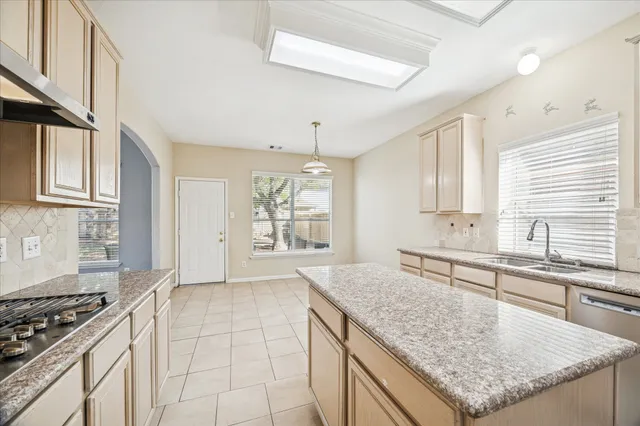 a kitchen with stainless steel appliances granite countertop a sink stove and cabinets