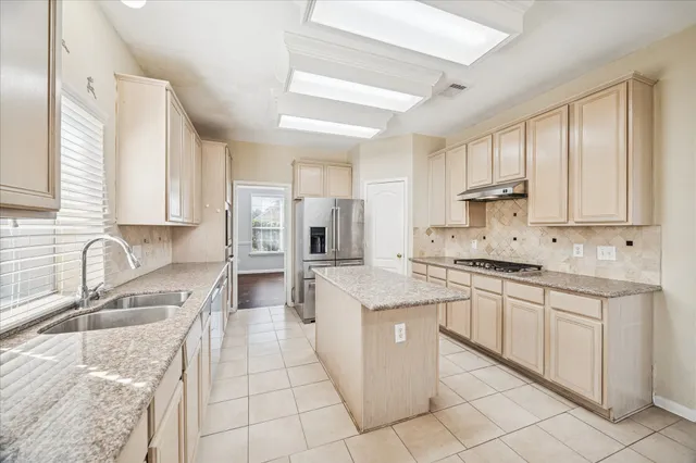 a kitchen with stainless steel appliances granite countertop a sink stove and cabinets