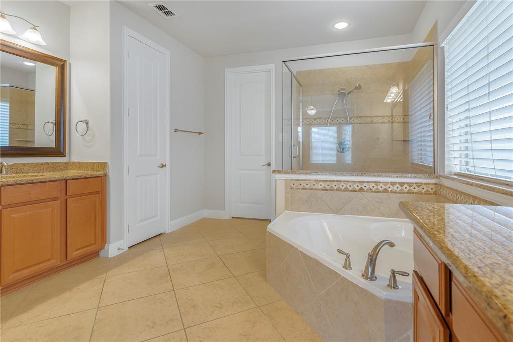 4560 Cheetah Trail Frisco, TX 75034 - Photo 13 of 38 a bathroom with a granite countertop tub sink and mirror