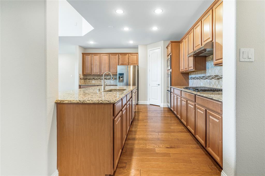 4560 Cheetah Trail Frisco, TX 75034 - Photo 10 of 38 a kitchen with stainless steel appliances granite countertop a stove and a sink