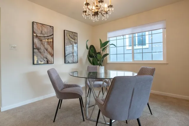a view of a dining room with furniture and a chandelier