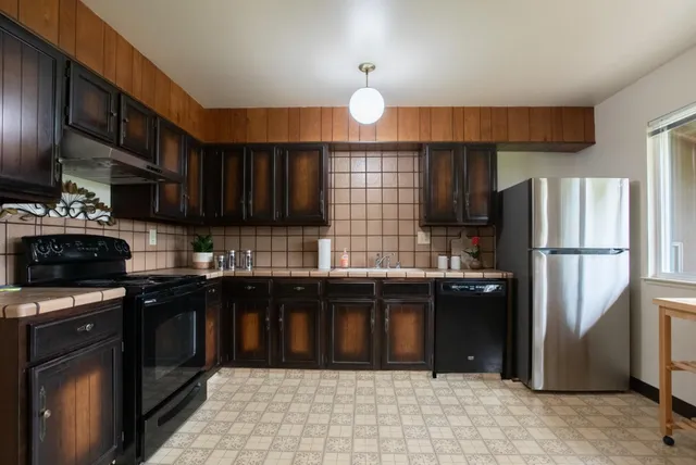 a kitchen with stainless steel appliances granite countertop a refrigerator and a stove top oven