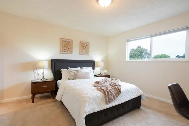 a bedroom with a bed and a painting on the wall