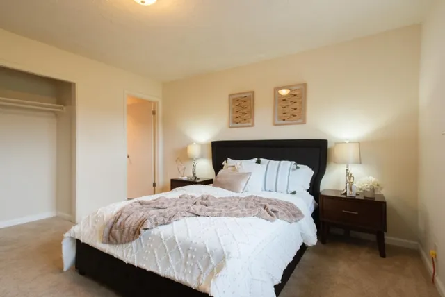 a bathroom with a granite countertop bathtub shower sink vanity and toilet