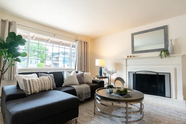 a living room with furniture fireplace and window