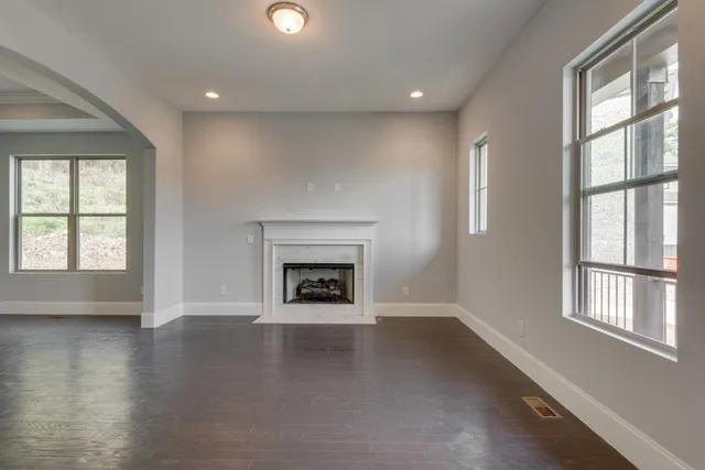 a view of a livingroom with wooden floor and a fireplace