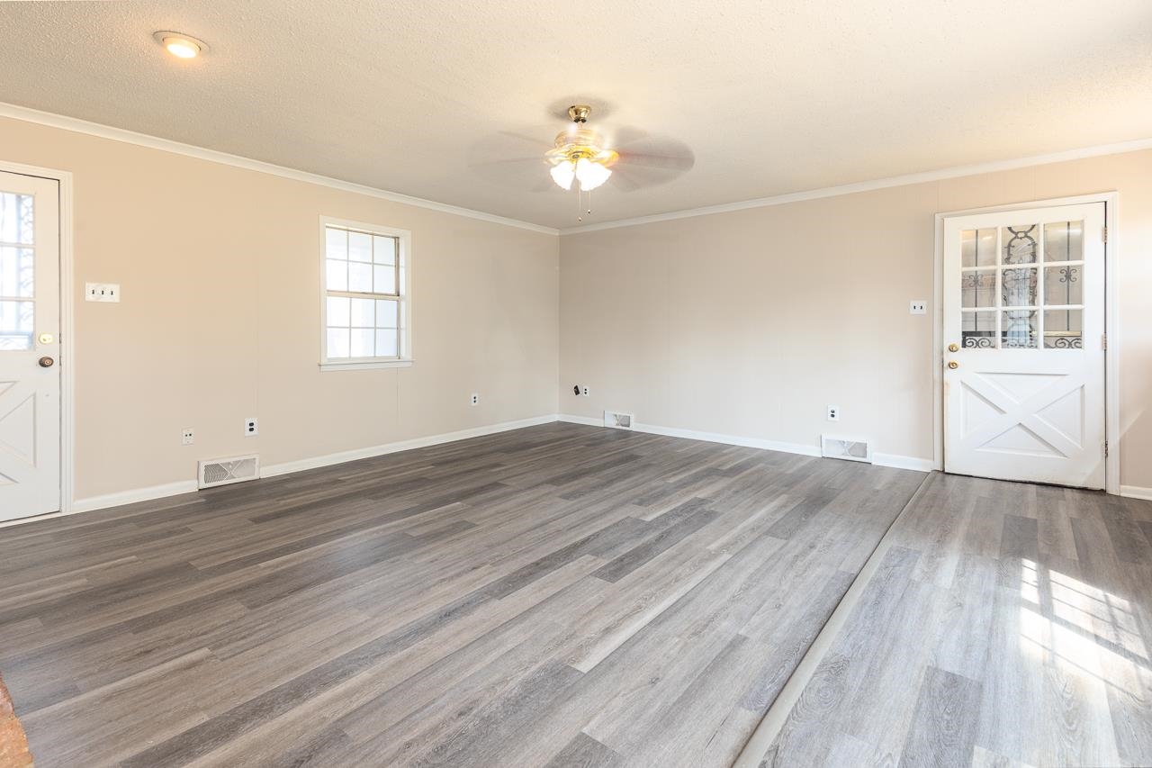 2718 Kate Bond Road Memphis, TN 38133 - Photo 6 of 39 Unfurnished room with crown molding, dark wood finished floors, ceiling fan, and a textured ceiling