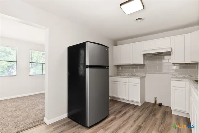 a kitchen with a refrigerator and cabinets