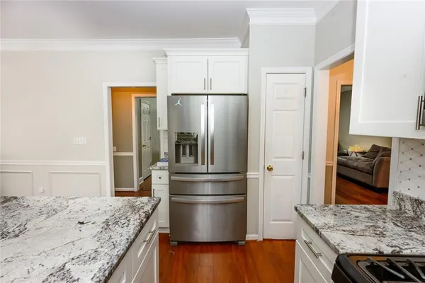 a kitchen with granite countertop a refrigerator and a sink