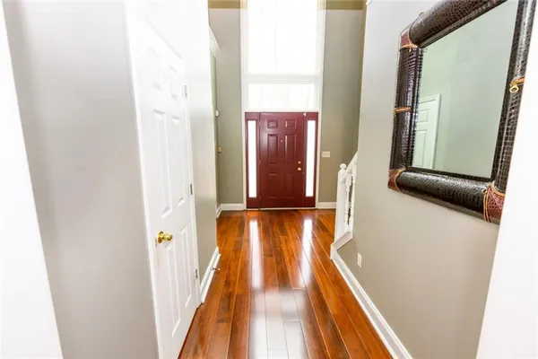 a view of a hallway with wooden floor and staircase