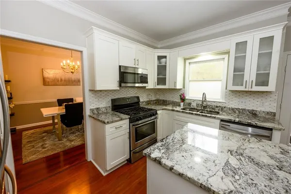 a kitchen with a stove a sink and a microwave