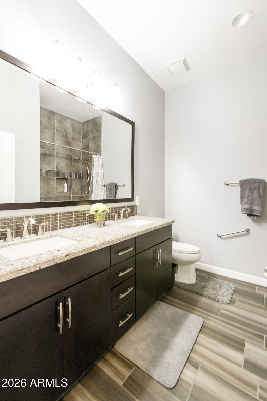 4777 South Fulton Ranch Boulevard, Unit 1086 Chandler, AZ 85248 - Photo 23 of 67 a spacious bathroom with a granite countertop sink a toilet and a mirror