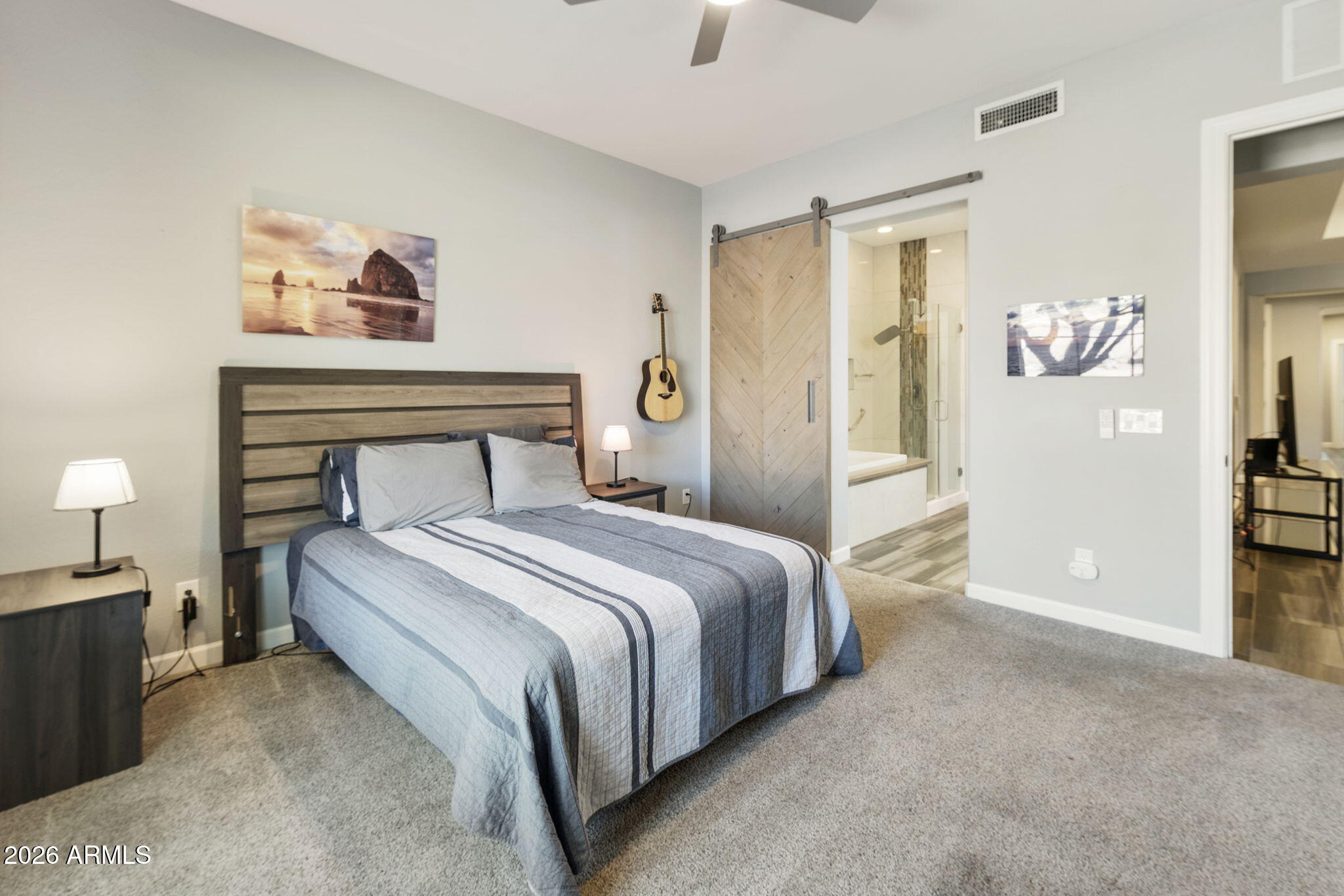 4777 South Fulton Ranch Boulevard, Unit 1086 Chandler, AZ 85248 - Photo 29 of 67 a bedroom with a bed and a lamp on table