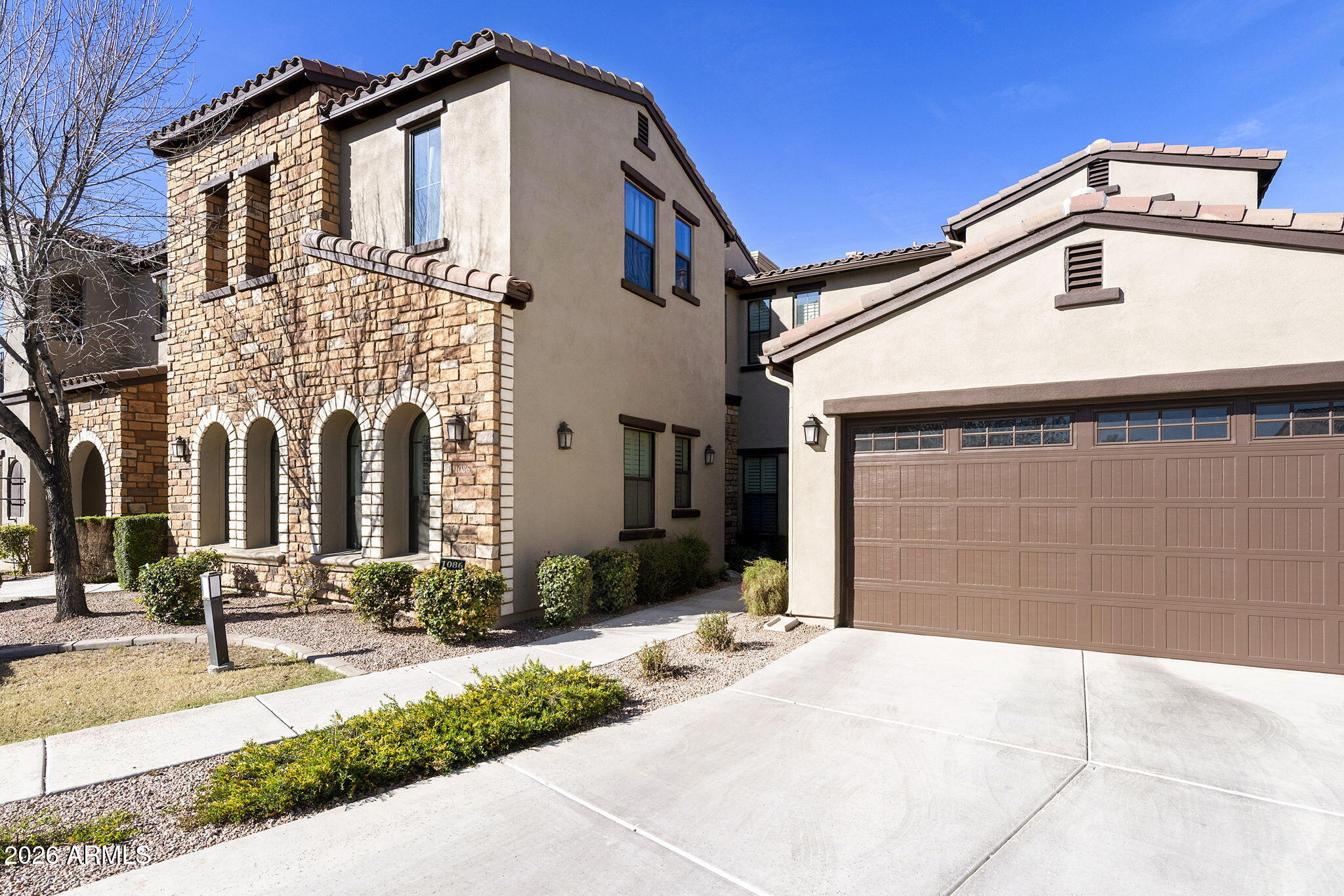 4777 South Fulton Ranch Boulevard, Unit 1086 Chandler, AZ 85248 - Photo 34 of 67 a front view of a house with a yard and garage