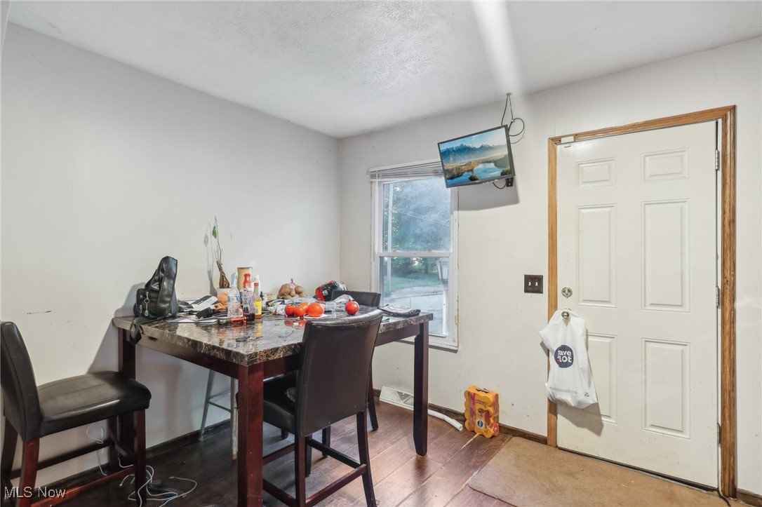 1042 Ansel Road Cleveland, OH 44103 - Photo 15 of 36 Dining area featuring a textured ceiling and wood-type flooring