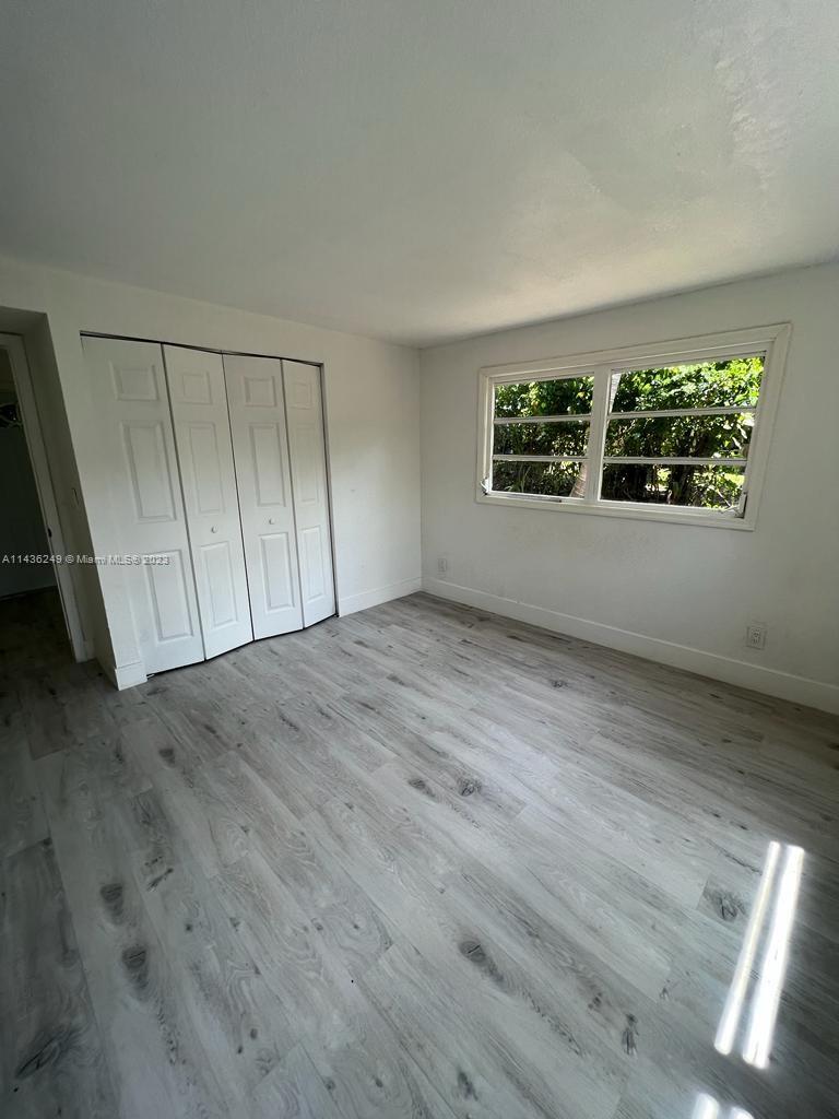 5836 Hope Street Hollywood, FL 33021 - Photo 14 of 24 an empty room with wooden floor and windows