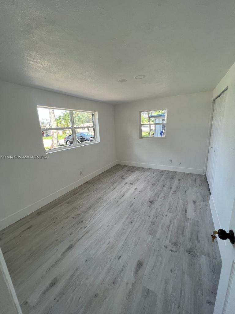 5836 Hope Street Hollywood, FL 33021 - Photo 17 of 24 an empty room with wooden floor and windows