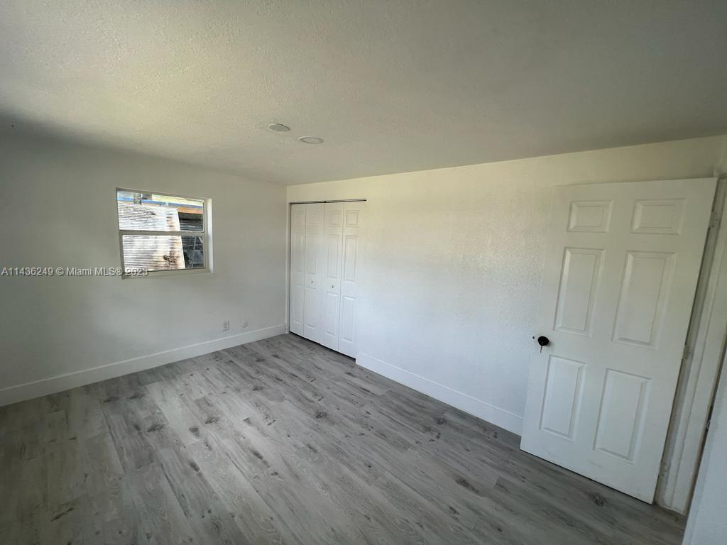 5836 Hope Street Hollywood, FL 33021 - Photo 18 of 24 a view of an empty room with wooden floor and a window
