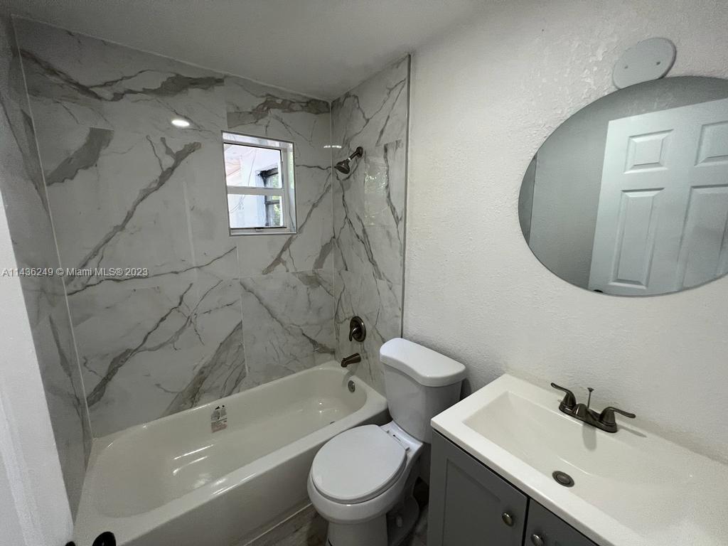 5836 Hope Street Hollywood, FL 33021 - Photo 19 of 24 a bathroom with a sink a toilet and a mirror