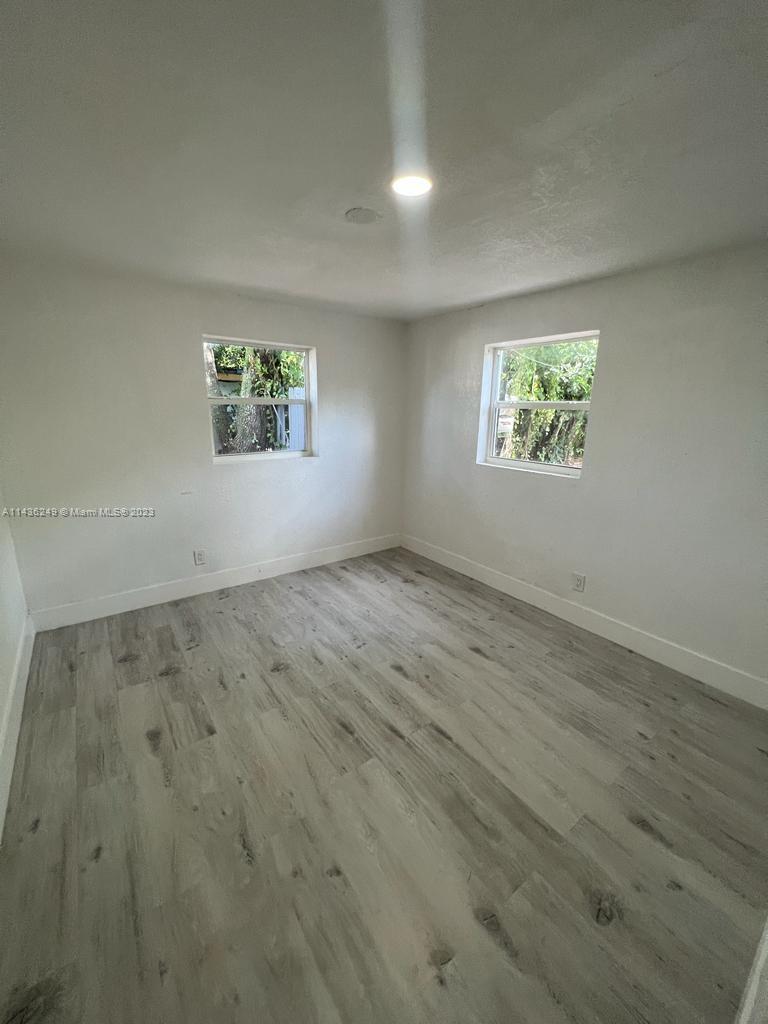 5836 Hope Street Hollywood, FL 33021 - Photo 21 of 24 an empty room with wooden floor and windows