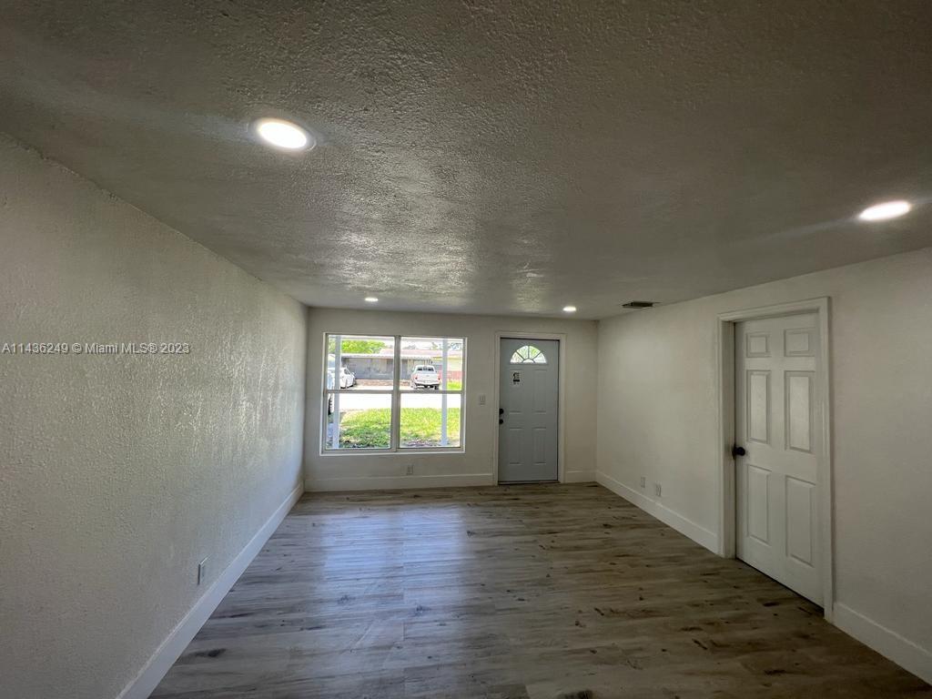 5836 Hope Street Hollywood, FL 33021 - Photo 5 of 24 an empty room with wooden floor and windows
