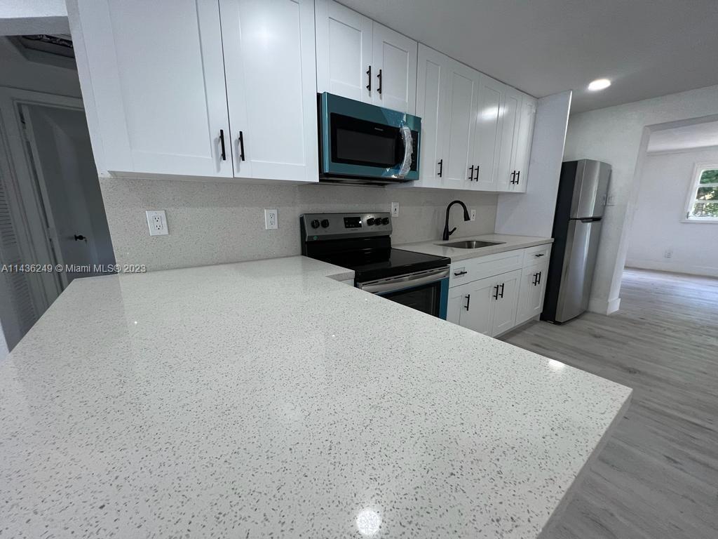 5836 Hope Street Hollywood, FL 33021 - Photo 7 of 24 a kitchen with stainless steel appliances a refrigerator sink and microwave