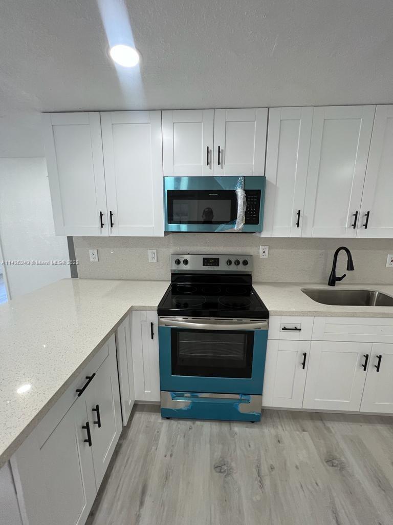 5836 Hope Street Hollywood, FL 33021 - Photo 8 of 24 a kitchen with cabinets appliances and a sink