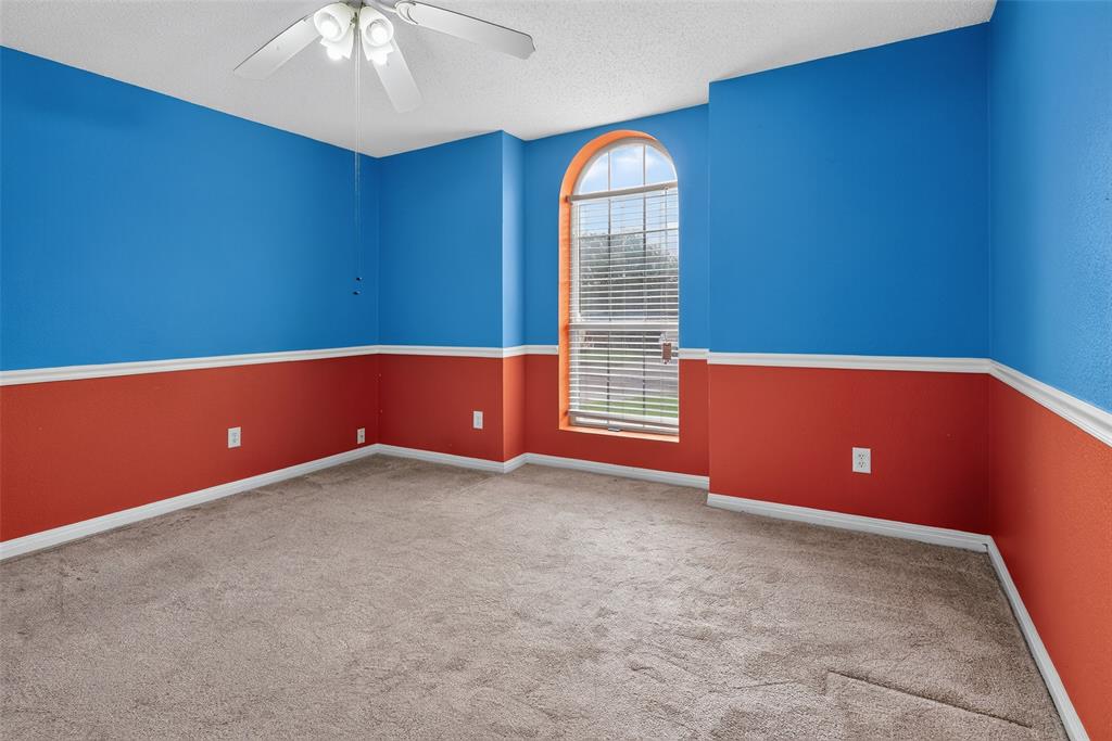 124 Topaz Circle Hewitt, TX 76643 - Photo 24 of 35 Carpeted room featuring a distinctive arched window with blinds, bi-color walls, and a ceiling fan