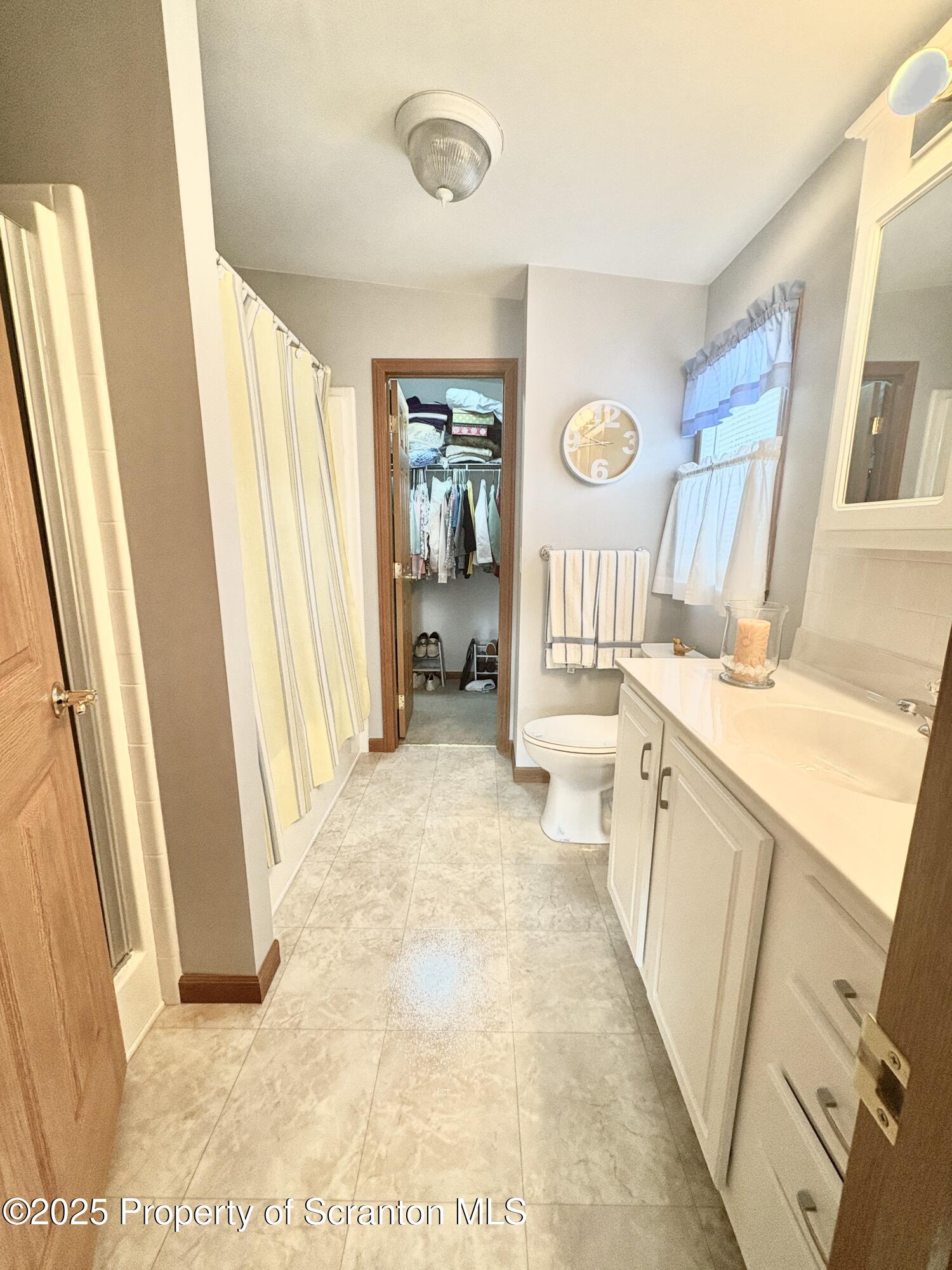 813 Poplar Street Clarks Summit, PA 18411 - Photo 9 of 33 a bathroom with a sink a toilet a mirror a vanity and a shower