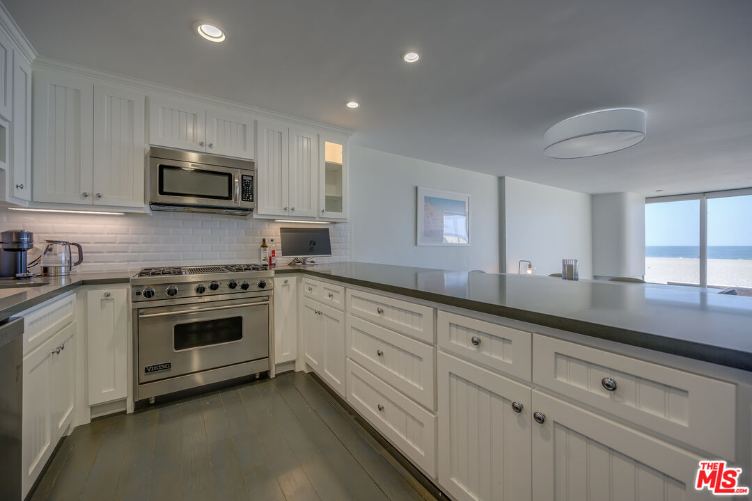 2 Ketch Street, Unit 107 Marina del Rey, CA 90292 - Photo 12 of 23 a kitchen with granite countertop white cabinets and stainless steel appliances