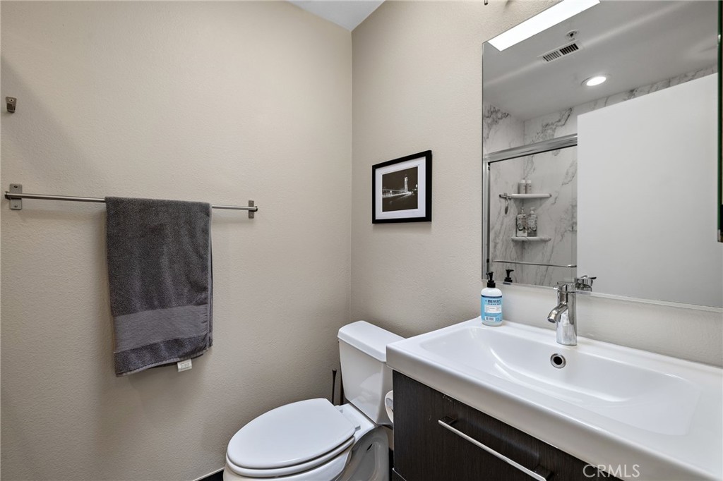17641 Sergio Circle, Unit 203 Huntington Beach, CA 92647 - Photo 15 of 25 a bathroom with a sink mirror vanity and toilet