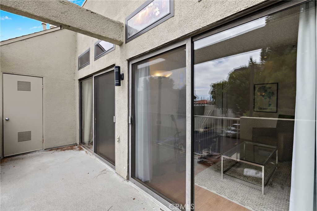 17641 Sergio Circle, Unit 203 Huntington Beach, CA 92647 - Photo 19 of 25 a view of a hallway with a glass door and glass door