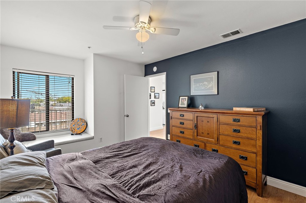 17641 Sergio Circle, Unit 203 Huntington Beach, CA 92647 - Photo 21 of 25 a bedroom with a bed and wooden floor