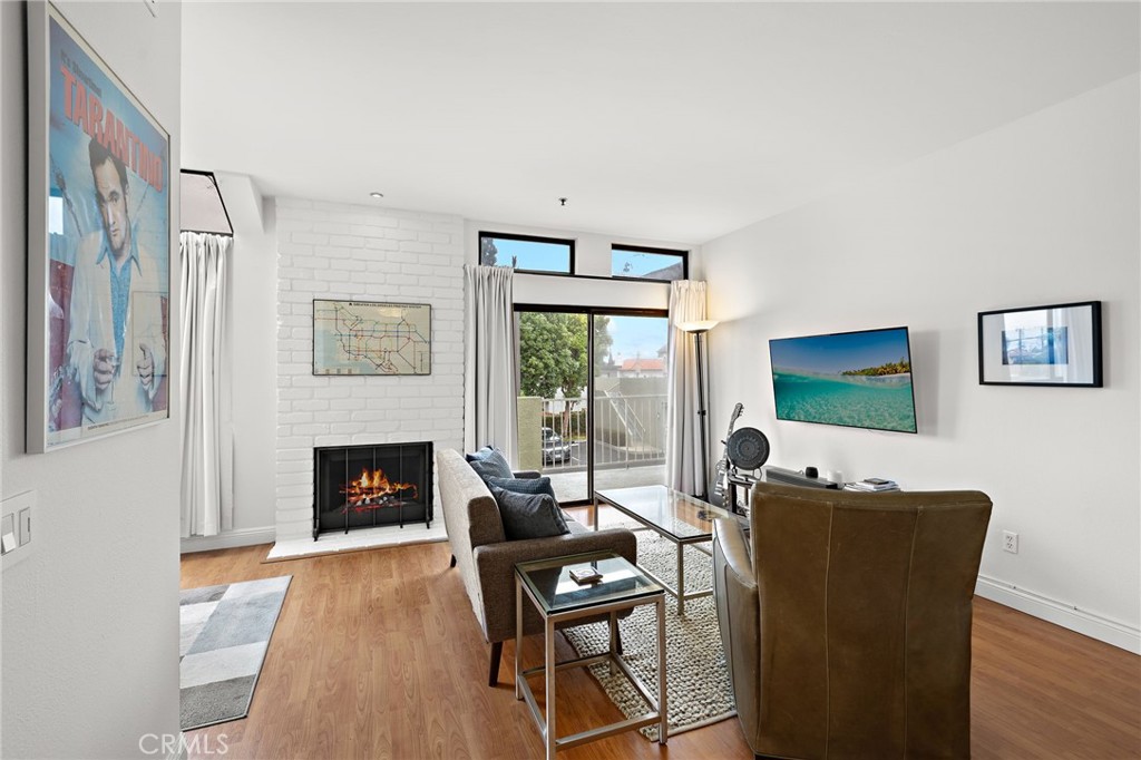 17641 Sergio Circle, Unit 203 Huntington Beach, CA 92647 - Photo 3 of 25 a living room with furniture a fireplace and a flat screen tv