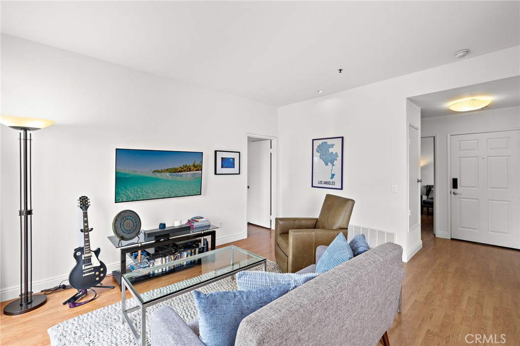 17641 Sergio Circle, Unit 203 Huntington Beach, CA 92647 - Photo 5 of 25 a room with furniture and a flat screen tv