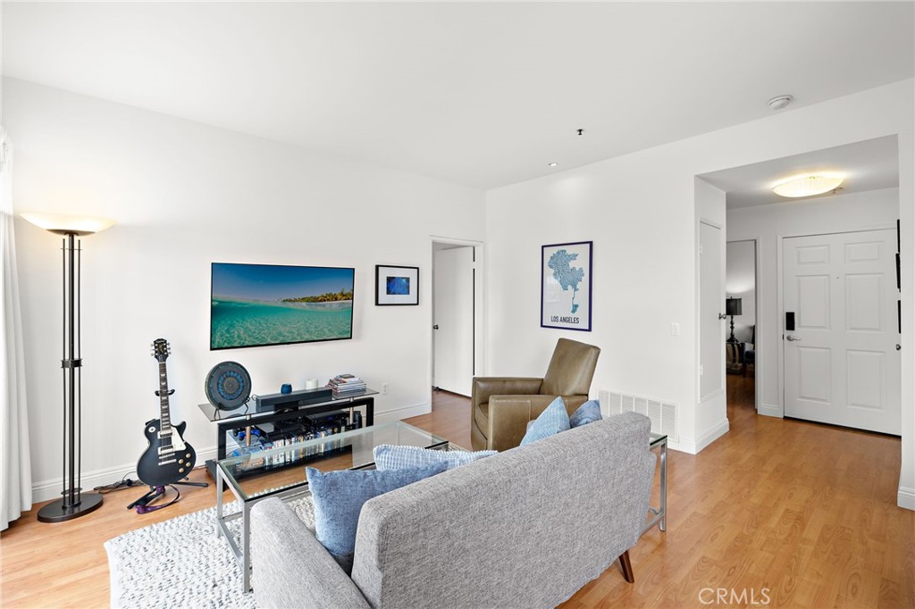 17641 Sergio Circle, Unit 203 Huntington Beach, CA 92647 - Photo 6 of 25 a living room with furniture and a wooden floor