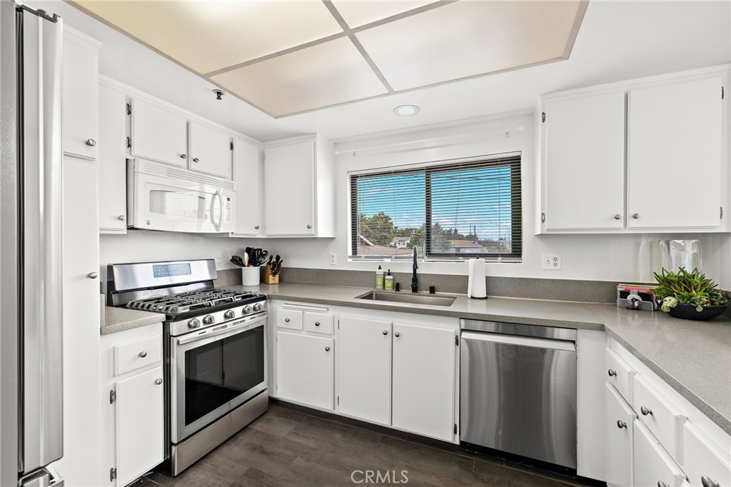 17641 Sergio Circle, Unit 203 Huntington Beach, CA 92647 - Photo 9 of 25 a kitchen with cabinets stainless steel appliances and a sink