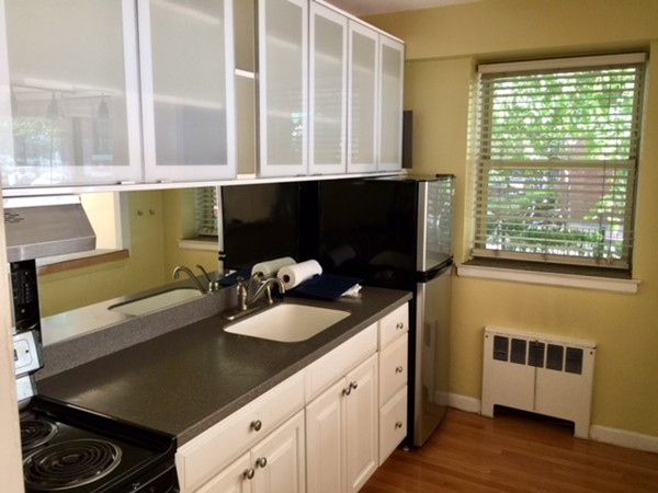 a kitchen with a sink and a stove next to a window