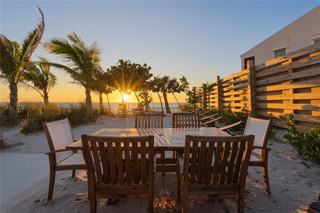 2630 North Beach Road Englewood, FL 34223 - Photo 4 of 98 a view of a roof deck with table and chairs potted plants and palm trees