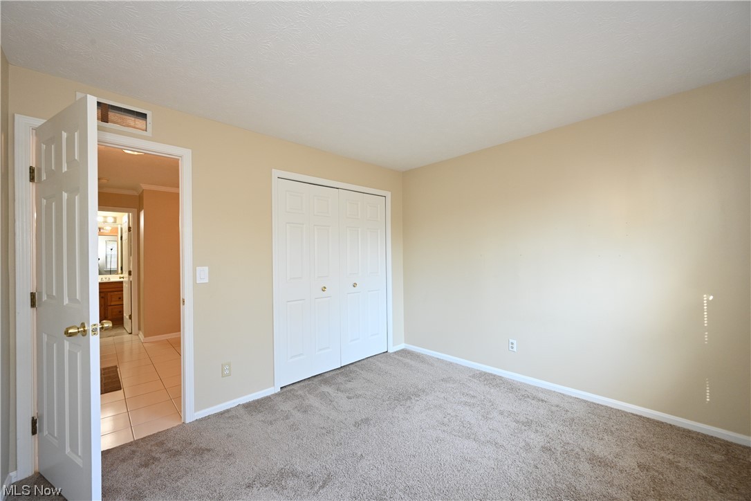 28140 Detroit Road, Unit A1 Westlake, OH 44145 - Photo 23 of 30 Unfurnished bedroom with a closet and light tile floors