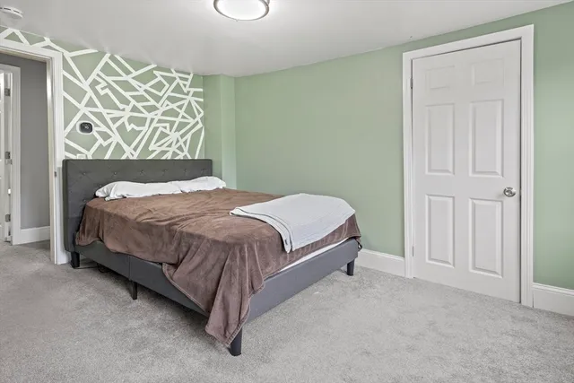a bedroom with a bed and painting on the wall