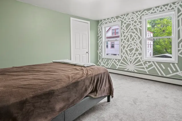 a bed sitting in a bedroom next to a window