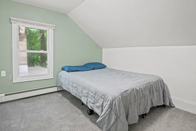 a bed sitting in a bedroom next to a window