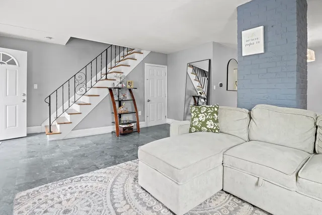 a living room with furniture and stairs