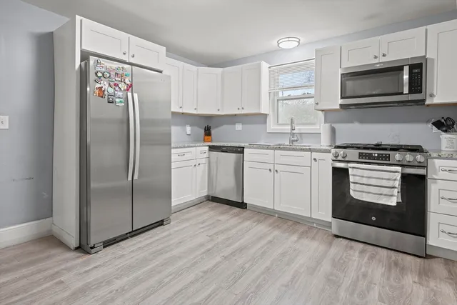 a kitchen with stainless steel appliances granite countertop a stove a refrigerator and a microwave