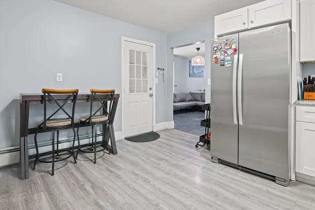 a kitchen with stainless steel appliances refrigerator dining table and chairs