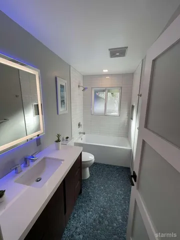 a bathroom with a double vanity sink a mirror and a bathtub