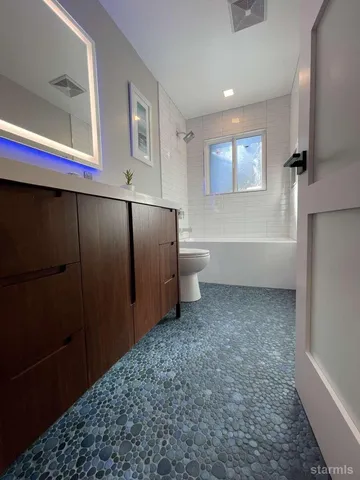 a bathroom with a toilet sink and mirror