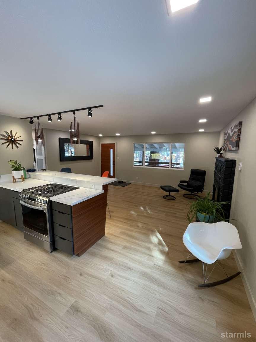 694 Sand Harbor Road South Lake Tahoe, CA 96150 - Photo 6 of 20 a large kitchen with stainless steel appliances kitchen island granite countertop a sink dishwasher and a stove with wooden floor